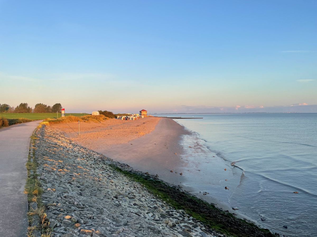Ein Weg führt am Sandstrand von Hooksiel mit seinen Strandkörben entlang.